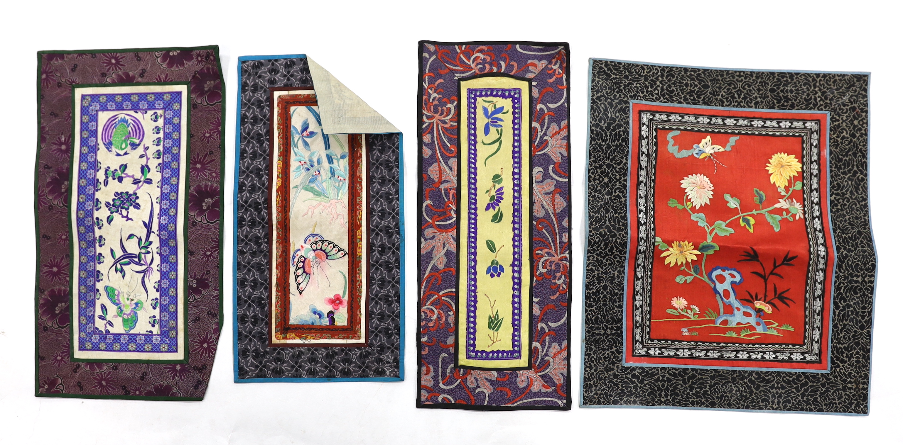 Twelve various Chinese rectangular silk polychrome embroidered mats with damask borders, of varying sizes